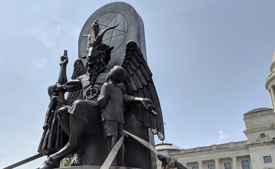 The Satanic Temple unveils its statue of Baphomet, a winged-goat creature, at a rally in Little Rock, Ark., Thursday. The group wants to install the statue on Capitol grounds because a monument of the Ten Commandments was placed there in 2017.