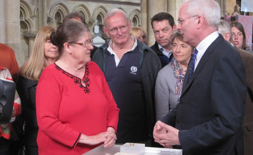 Jewellery specialist Geoffrey Munn is filmed discussing the value of a ring with a visitor.