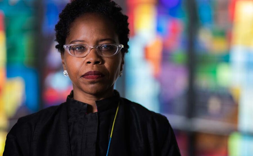 Reverend Stacey Edwards-Dunn stands in front of a stained glass window at Trinity United Church of Christ in Chicago. She discusses the challenges of infertility for African Americans, especially women, and is the Founder of Fertility for Colored Girls, a group advocating for black women experiencing infertility. Rev. Stacey struggled with infertility herself before finally having her daughter, Shiloh.