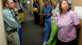 Dr. Dave Yehl (left) meets with nurses and a scheduler for a twice-a-day hallway huddle. Under the experimental payment scheme, the team is taking a more wellness-oriented approach.