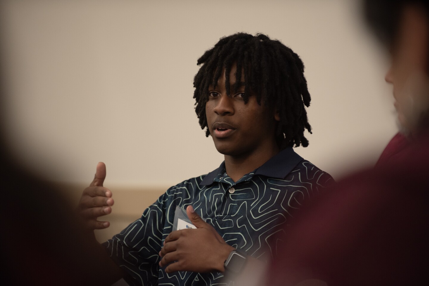 Izayah Ringfield discusses with other South Bay community leaders at the San Ysidro library on Tuesday, Feb. 20, 2024.