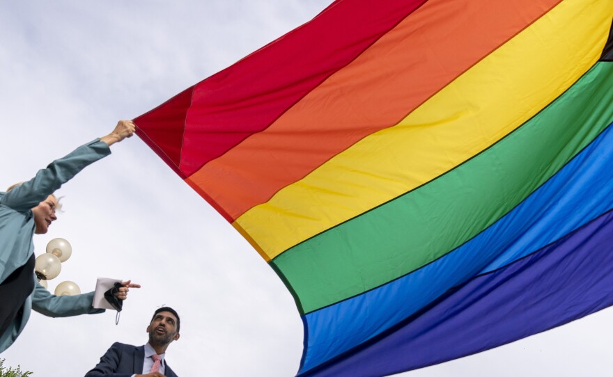 Energy Secretary Jennifer Granholm and Department of Energy Chief of Staff Tarak Shah help raise the Progress Pride Flag outside the Department of Energy in Washington, Wednesday. The Pentagon decided not to allow the flag to fly on military installations for Pride Month.