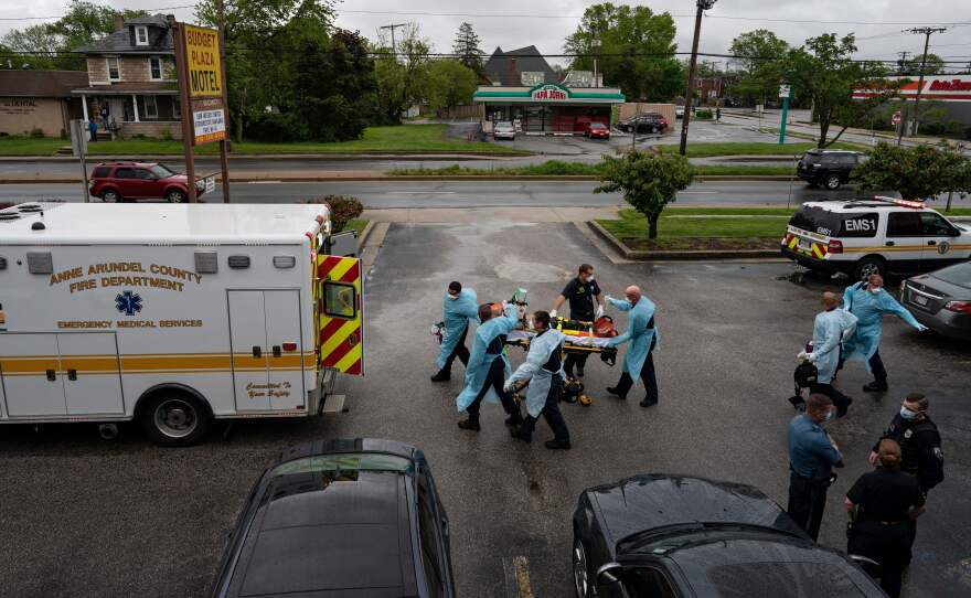 Firefighters and paramedics with the Anne Arundel County Fire Department in Maryland wear enhanced PPE, during the coronavirus pandemic, as they transport a patient after responding to a call for a cardiac arrest as a result of a drug overdose on May 6, 2020.