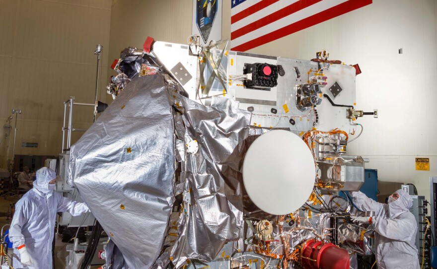 Workers assemble OSIRIS-REx in a clean room at Lockheed Martin. Solar panels were added afterward to power the voyage.