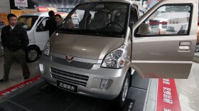 Visitors look at minivans at a GM joint venture dealership in China. GM and its partner, Wuling, sold more than 560,000 of their Sunshine minivan in China last year.