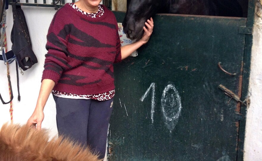 Concordia Márquez, founder of the CYD Santa Maria shelter, poses with two horses she adopted.
