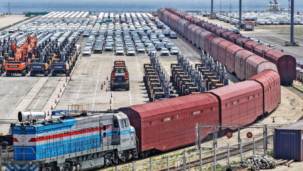 Heavy equipment and cars are prepared for shipment by rail in Yantai, eastern China's Shandong province, on June 20, 2026.
