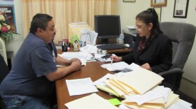 Helena Garcia looks over paper work with Fernando Terriquez in her office. Terriquez has seen Garcia help other immigrants get back money they are owed, so asked for her help getting proper payment from his employer.