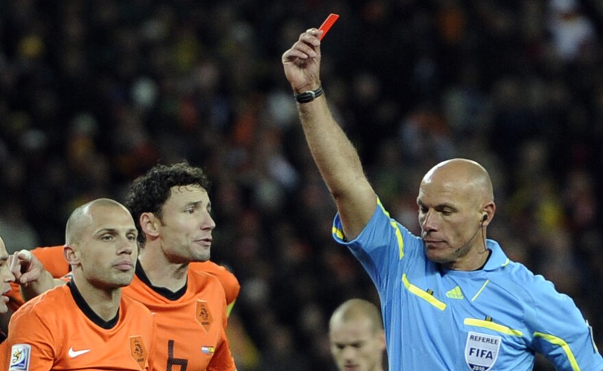 Referee Howard Webb of England, right, shows the red card to Netherlands' John Heitinga, left, during the World Cup final soccer match between the Netherlands and Spain at Soccer City in Johannesburg, South Africa, Sunday, July 11, 2010.