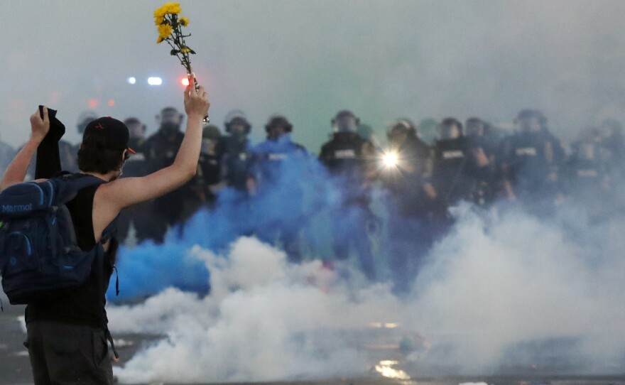 Police move towards a protester after curfew Saturday, May 30, 2020, in Minneapolis.