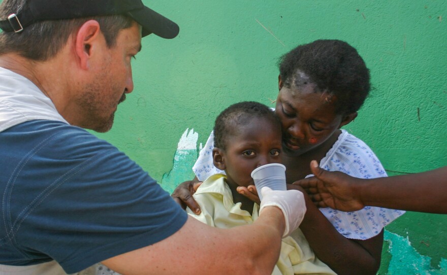 Dr. Lance Plyler with Samaritan's Purse bandages a boy's broken ankle in the parking lot of the main hospital in Les Cayes. The 3-year-old broke his ankle in the aftermath of the hurricane.