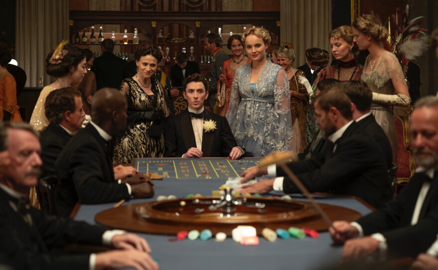 Leah (Charlene McKenna) and Clara (Luise von Finckh) watch as Max (Matthew Beard, center) tries his luck at roulette in Rieger’s casino.