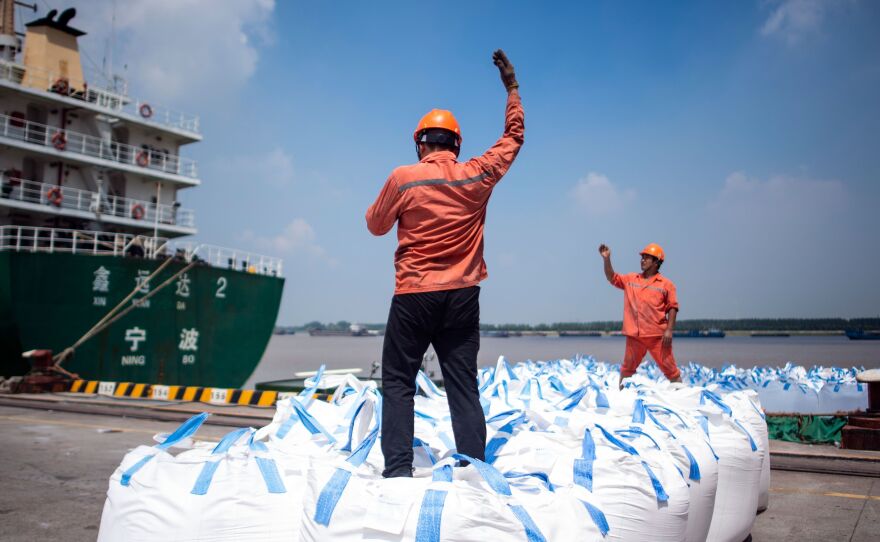 Dock workers unload bags of chemicals earlier this month at a port in Zhangjiagang, north of Shanghai.