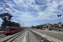 A Blue Line trolley passes by single-family homes in Bay Park, Aug. 25, 2025.