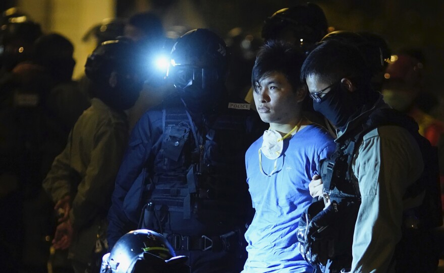 Riot police detain a protester on Tuesday near Hong Kong Polytechnic University, where  about 100 anti-government protesters remained holed up.