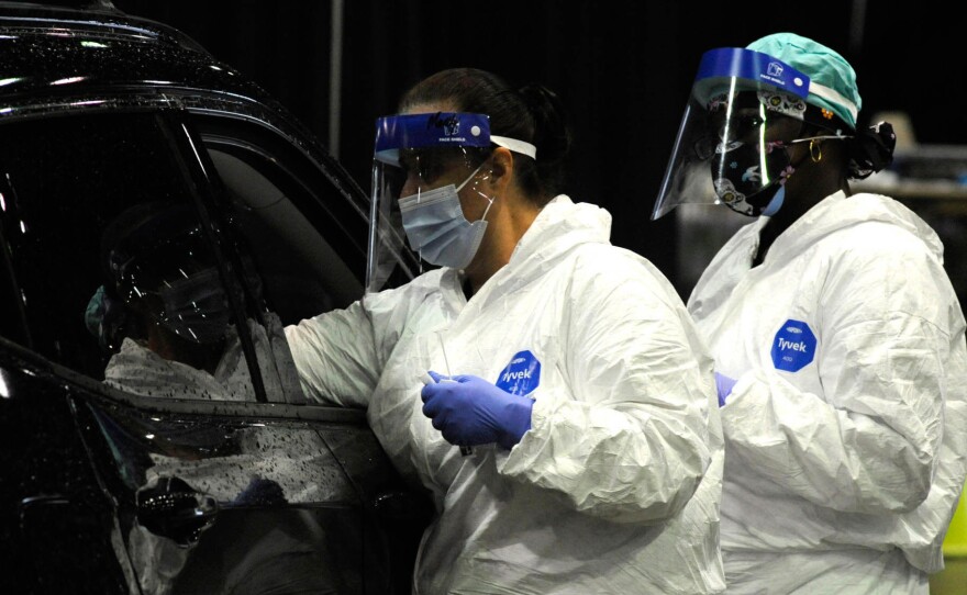 A medical worker tests a person for COVID-19 last month in Mobile, Ala. A surge of coronavirus cases in the state has stretched hospital ICUs to capacity, making it difficult for patients with other conditions to find ICU beds.