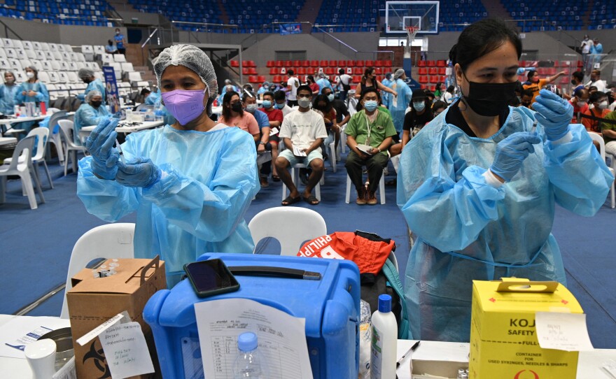 Health workers prepare COVID-19 vaccines at a coliseum in suburban Manila on November 29 — part of a massive 3-day vaccination drive launched by the government. It was one of 8,000 vaccination centers set up during the drive.