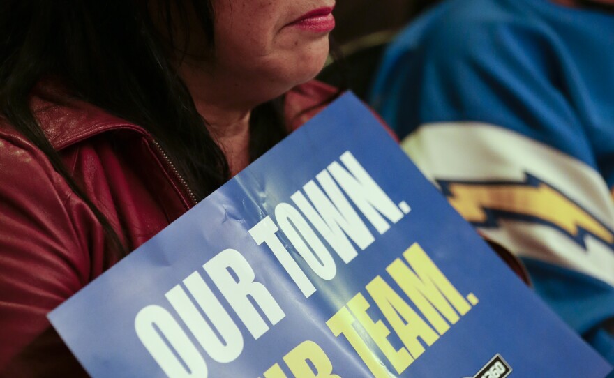 Loraine Ramirez holds a sign that says "Our Town, Our Team" during a hearing hosted at the Spreckels Theatre by the NFL to gather comments from football fans on the possible relocation of the San Diego Chargers to Los Angeles, Oct. 28, 2015.