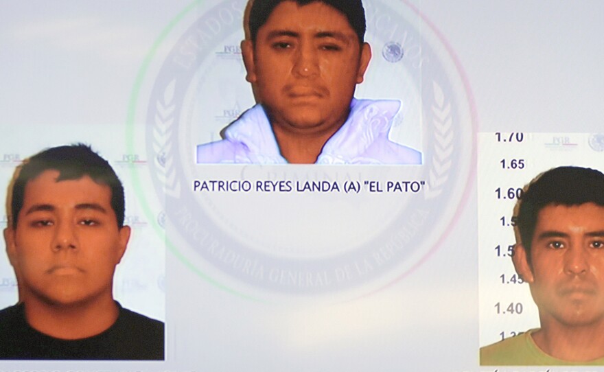 Pictures of the detainees for the case of missing students are seen displayed on a television screen during a news conference at the Attorney General's Office building in Mexico City on Friday.