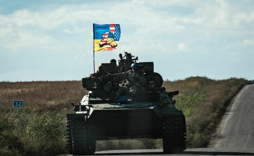 A Ukrainian tank moving through Novostepanivka, Kharkiv region on Sept. 19, 2022 flies a flag representing Ukrainian and American cooperation.