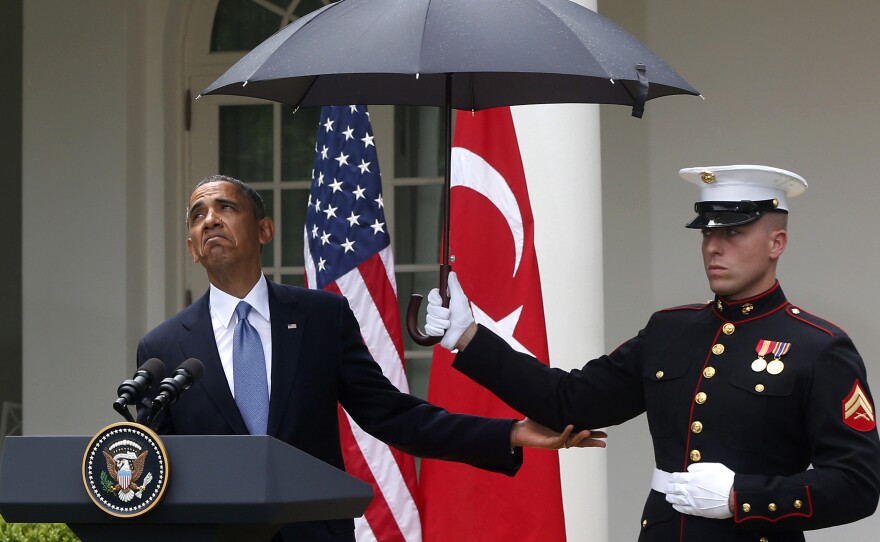 President Obama checks to see if it's still raining as a Marine holds an umbrella for him during a joint news conference with Turkish Prime Minister Recep Tayyip Erdogan at the White House on Thursday.