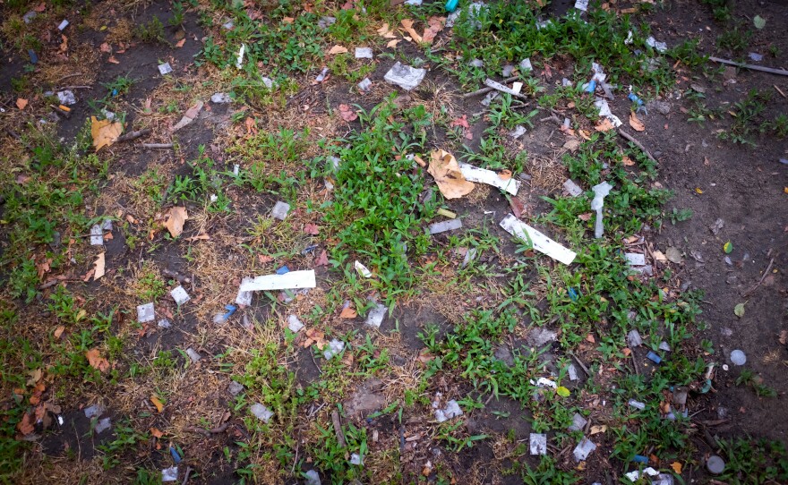 Baggies, needles and trash litter the park just a short distance from the baseball field.