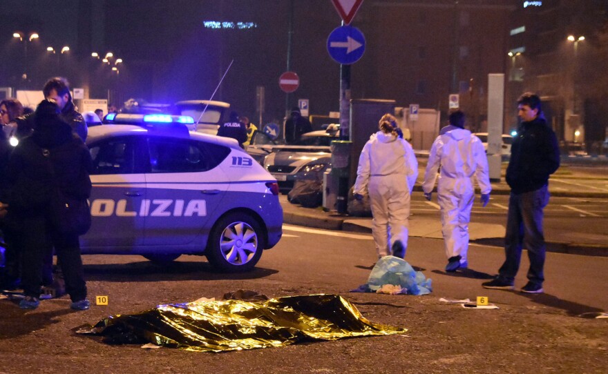 A body is covered with a thermal blanket after a shootout between Italian police and a man near a train station in Milan's Sesto San Giovanni neighborhood early Friday. Italy's interior minister said the man killed is "without a shadow of doubt" Anis Amri, the suspect in the Berlin Christmas market attack.