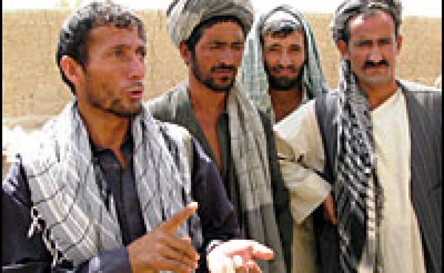 Farm cooperative head Mohammad Yusuf, left, talks about the drought and lack of government help that have left his village's farmlands decimated.