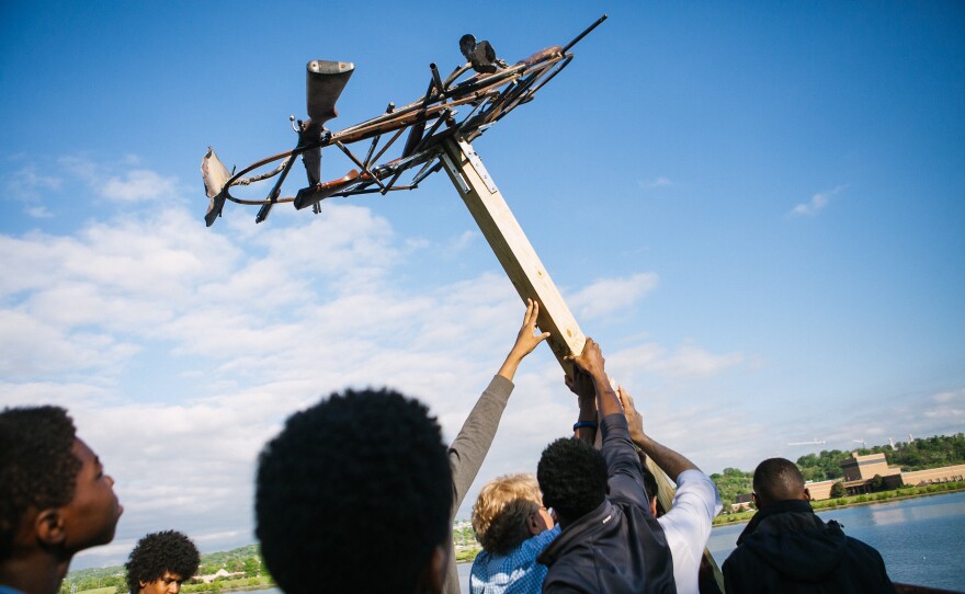 Students help raise the base of a new osprey nest, welded from parts including decommissioned firearms seized by the D.C. police.