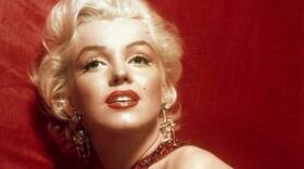 A glamorous Marilyn Monroe in a red dress, photographed by Sam Shaw.
