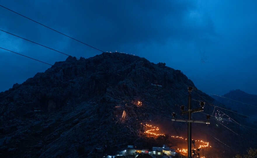 Traditionally, people in Akre carry flaming torches up the mountain to light a large fire on top. But this year's festivities were more subdued compared to past years because of the ongoing war in Iran and heavy rain.