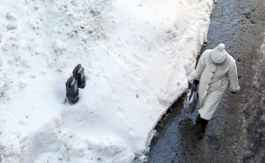 Parking meters sits mostly buried in a mound of snow on Friday in downtown Boston.