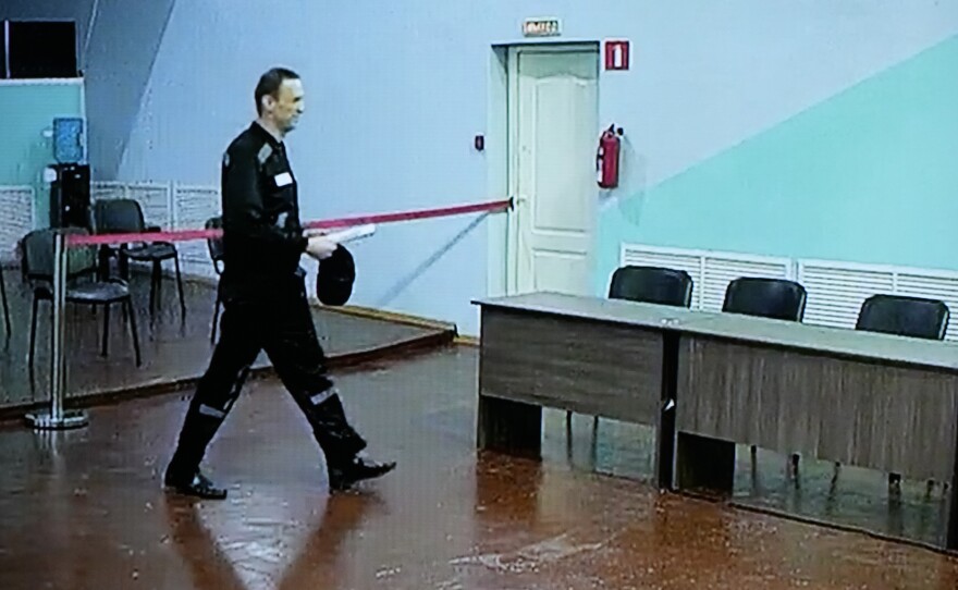 Russian opposition leader Alexei Navalny is seen on a TV screen, as he appears in a video link provided by the Russian Federal Penitentiary Service, during a hearing in the penal colony in Melekhovo, northeast of Moscow, on Friday.