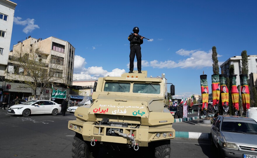 A member of police special forces stands guard on top of a vehicle in downtown Tehran, Iran, Monday.