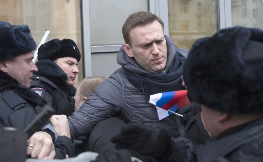 Russian opposition leader Alexei Navalny, center, is detained by police officers in Moscow, Russia on Sunday.
