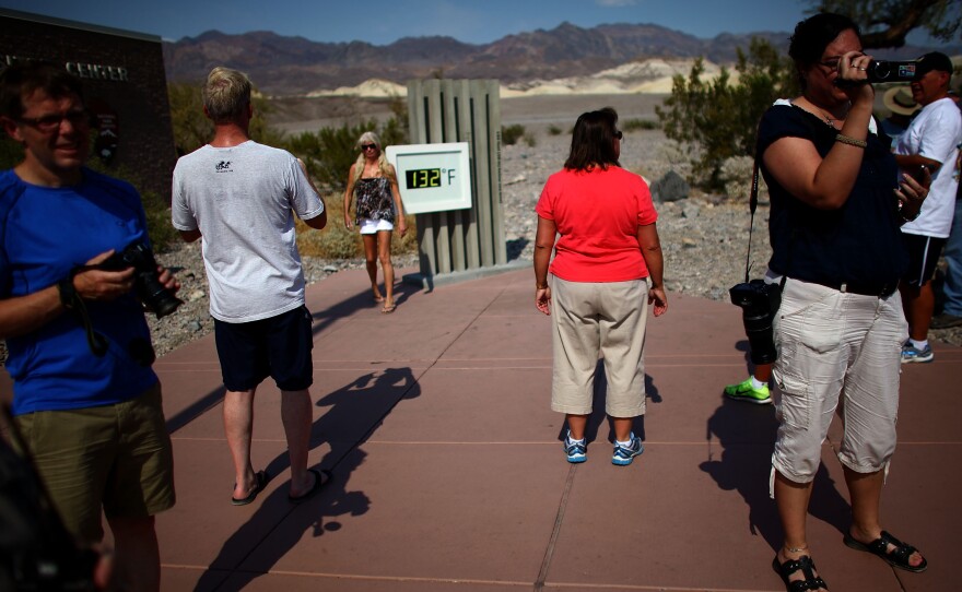 A crowd gathers at the temperature gauge outside the Furnace Creek Visitors on June 30. The temperature on the official thermometer was at 129 degrees in the shade.