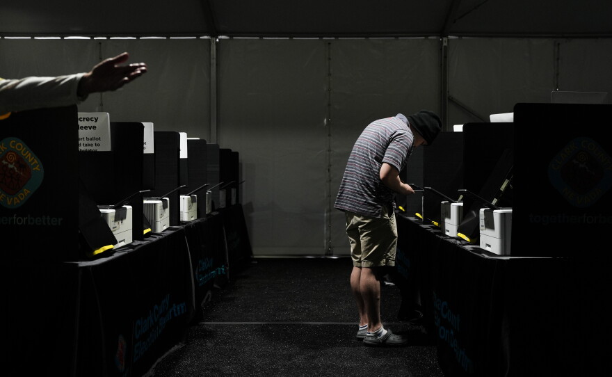 A voter casts a ballot at a vote center set up in a tent in Las Vegas on June 9.