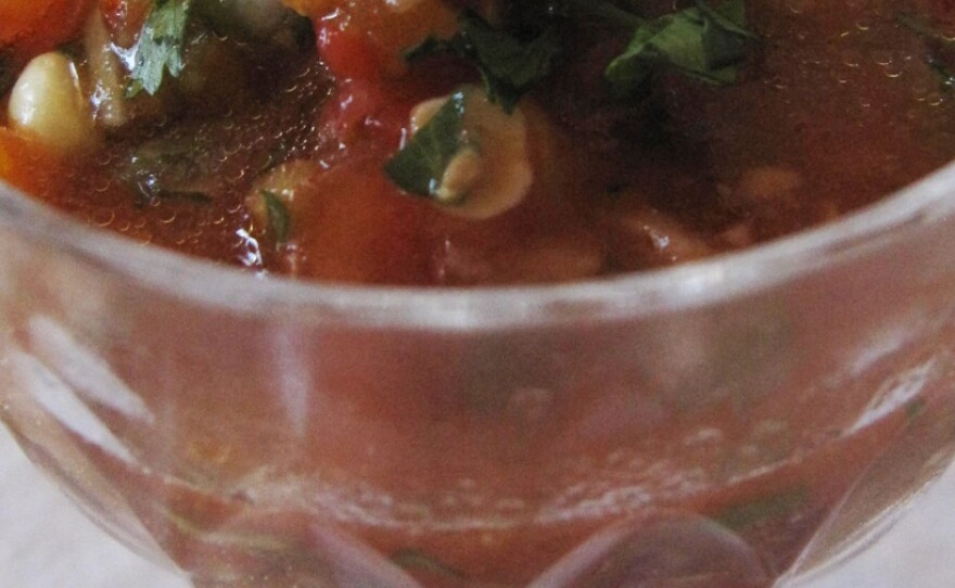 Cup of Gazpacho, a cold soup, made with tomatoes, cucumber, corn kernels and a dash of hot sauce.