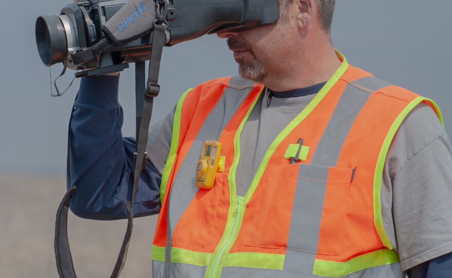Daniel Caldwell, a technician for Arthur's company, ALL Consulting, looks through an optical gas imaging camera at an oil well in the Tallgrass Prairie Preserve in Oklahoma on March 20, 2024.