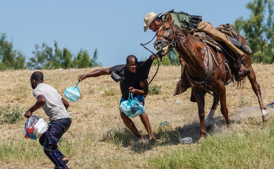 A United States Border Patrol agent on horseback tries to stop a Haitian migrant from entering an encampment on the banks of the Rio Grande near the Acuna Del Rio International Bridge in Del Rio, Texas on Sept. 19, 2021.