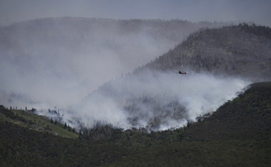 A helicopter drops water on the Cottonwood Fire in Beaver, Utah, on Saturday, June 27, 2026.