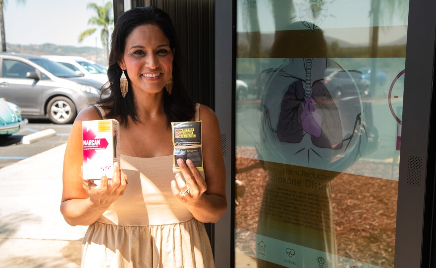 Amy Knox with the Harm Reducation Coalition, stands with Narcan and Fentanyl test strips provided by the first smart-vending machine on tribal lands on August 9, 2024. The machine, placed in a discreet location outside of Casino Pauma, is available to anyone who wants to use it. The machine vends Naloxone, commonly known as Narcan, as well as Fentanyl test strips, free of charge. The machine also provides information for common social services.