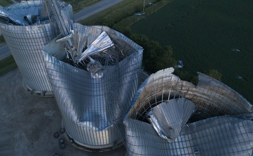 Damaged grain bins are shown at the Heartland Co-Op grain elevator on Aug. 11, 2020, in Malcom, Iowa. Some people are still recovering a year after the 2020 derecho caused $11 billion in damage across the Midwest.