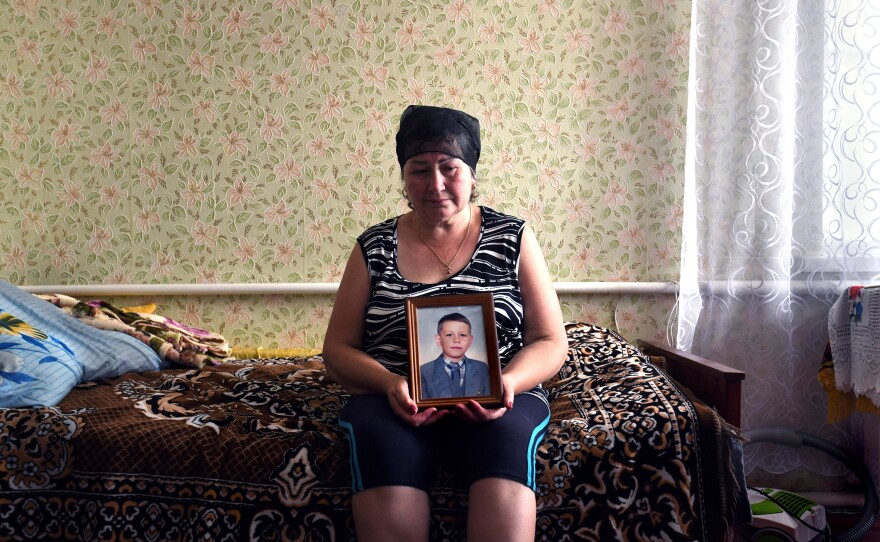 Oksana Breus holds a photo of her son, Oleksandr, at her home in Bobrovytsia.