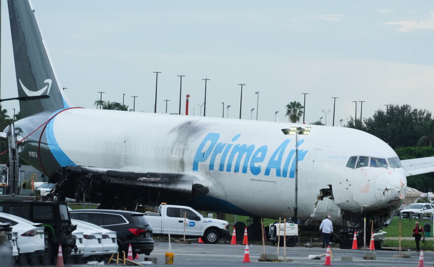 Workers inspect an Amazon cargo plane that overshot a runway four days ago at Miami International Airport, Thursday, Sept. 10, 2026, in Miami.