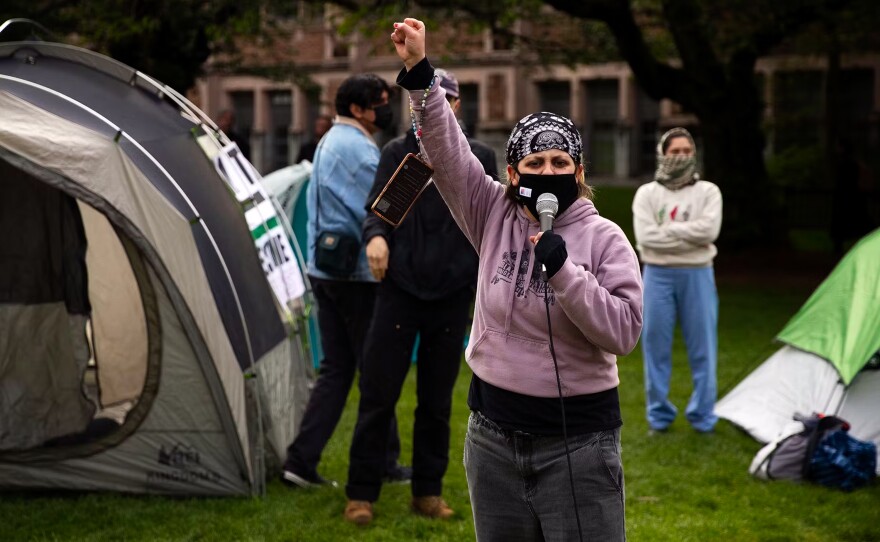 University of Washington alumni Gemini Gnull, with Freedom Road Socialist Organization, leads a chant as students set up what they are calling the UW Palestine Encampment on April 29, on the University of Washington campus in Seattle.