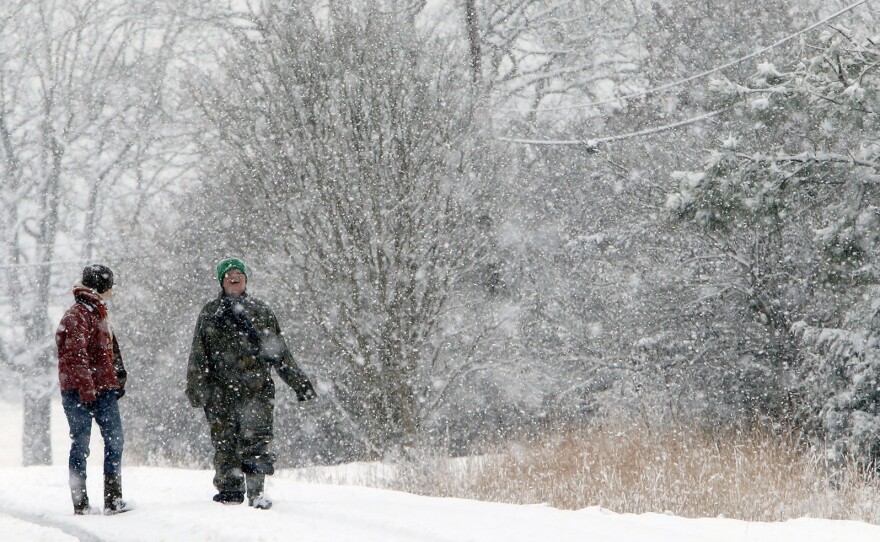 Ryann and Terri Camacho walked down highway 176 after checking on a neighbor's cows Tuesday near Dog Town, Ala. Their state was blanketed with snow by a storm and is in the path of another round of ice and snow today.