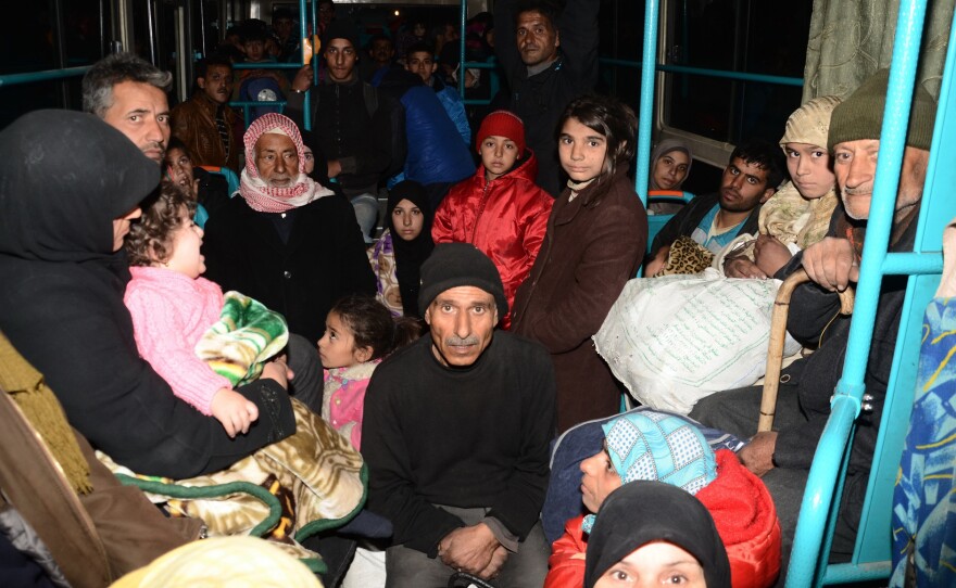 Syrian families from various eastern districts of Aleppo are evacuated by bus through Sheikh Maqsud, a Kurdish-controlled enclave between the government-held west of Aleppo and the east, on Sunday, as Syrian pro-government troops continue their advance toward rebel-controlled districts.