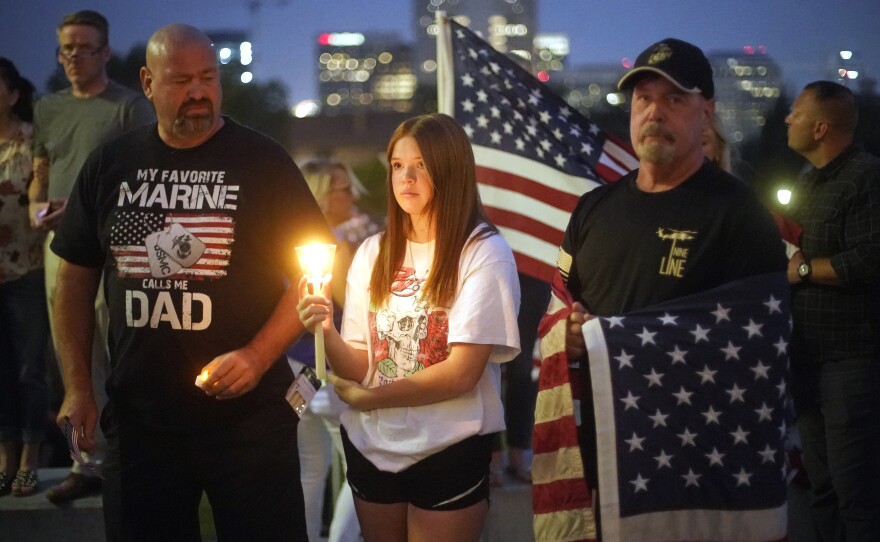 Sydney Robison, center, looks on during a vigil for U.S. Marines Staff Sgt. Taylor Hoover Sunday in Salt Lake City. Hoover was among the 13 U.S. troops killed in a suicide bombing at Kabul airport.