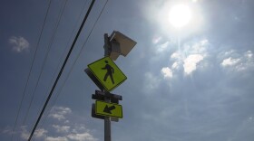 The sun glares over a crosswalk sign in front of Village View County Park in Fallbrook, Sept. 30, 2025.
